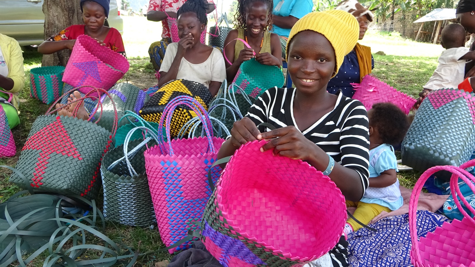 A participant works carefully on a handmade woven item.