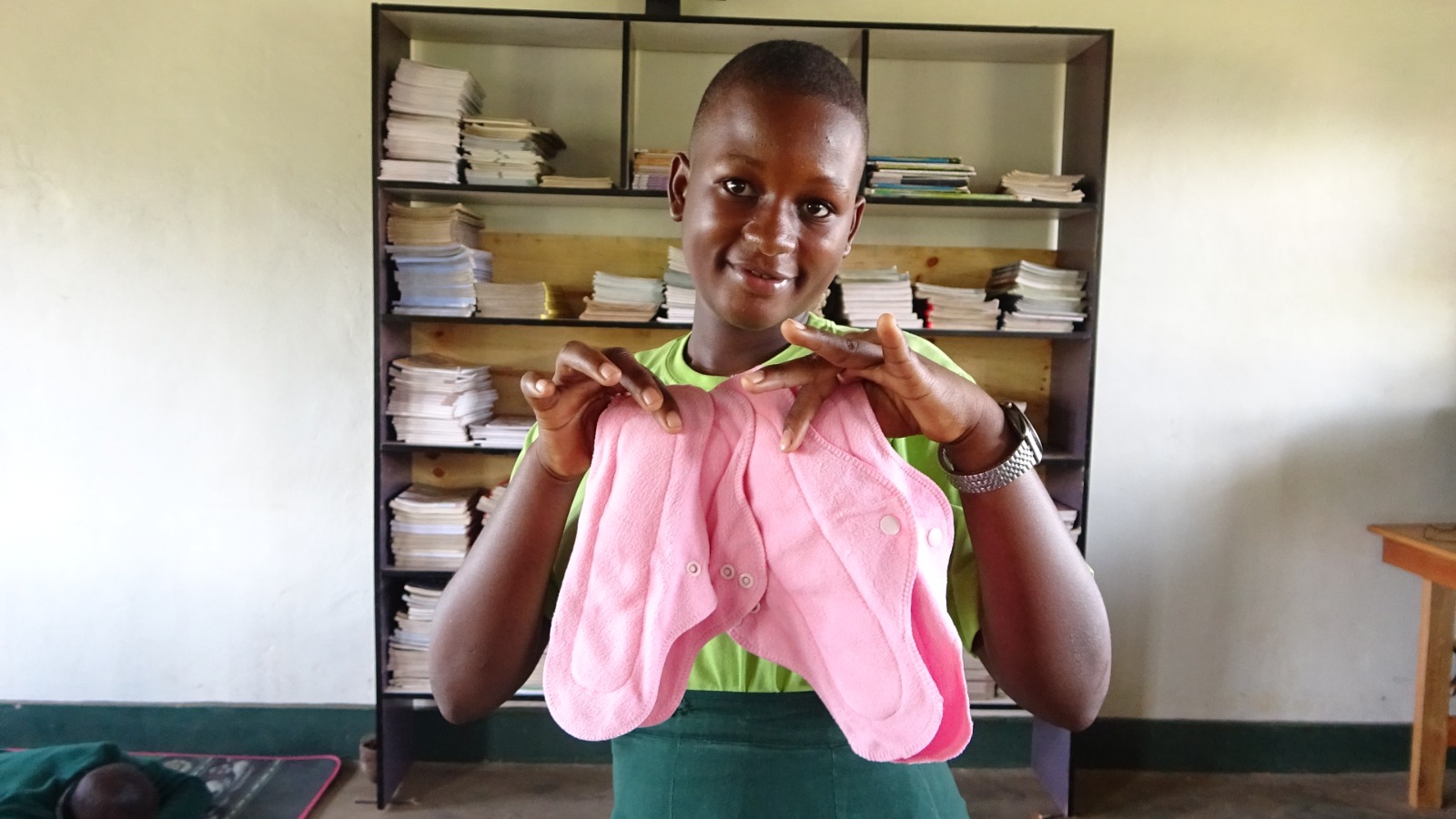 Student holding reusable menstrual pads in a classroom.