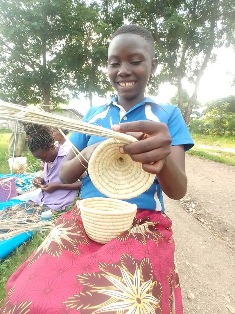 Teen girl weaving during a community training session.