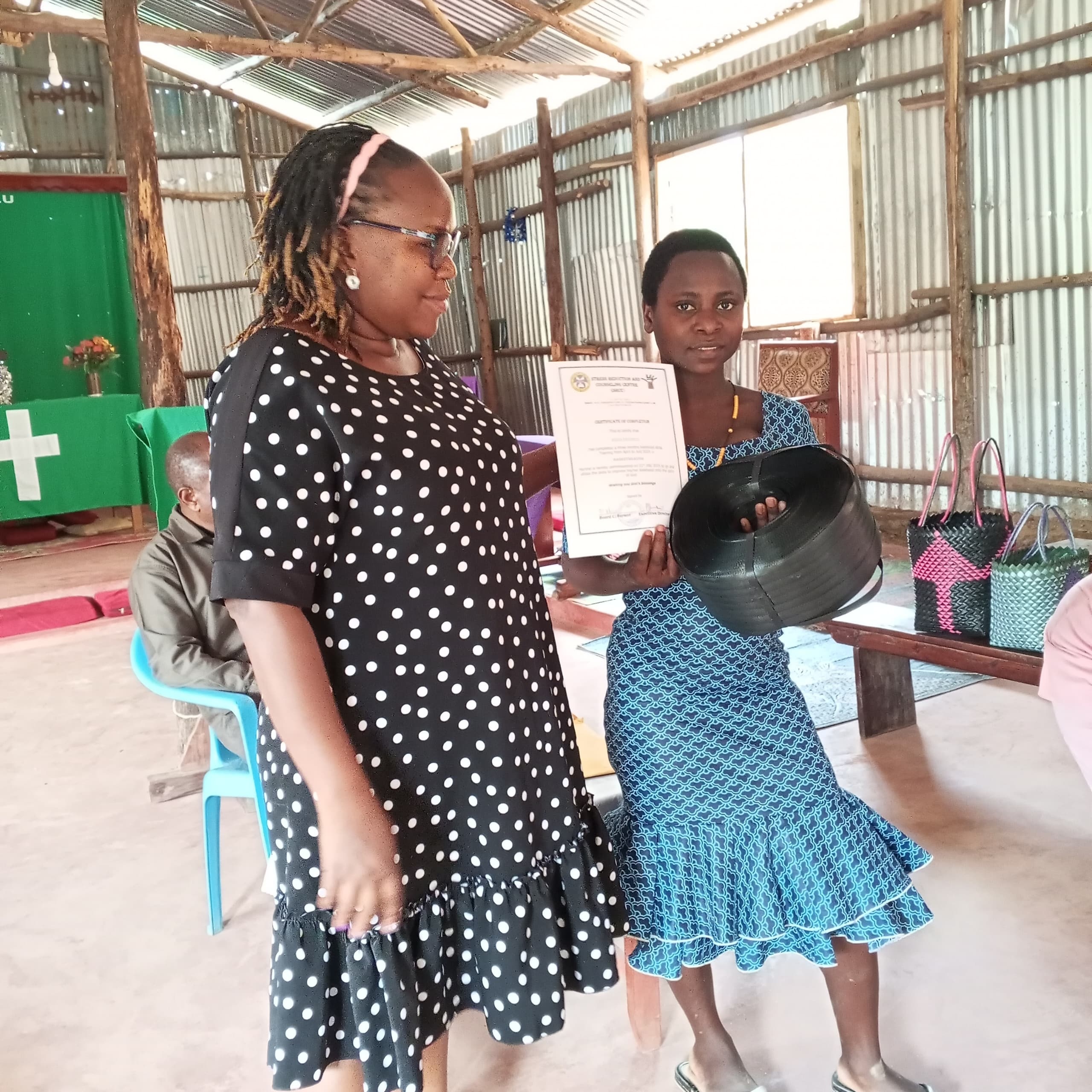 Biira receiving her startup kit and certificate from Mrs. Julie on graduation day.
