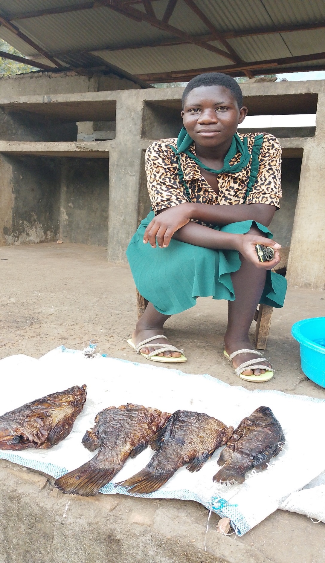 Robina at the market selling smoked mudfish.