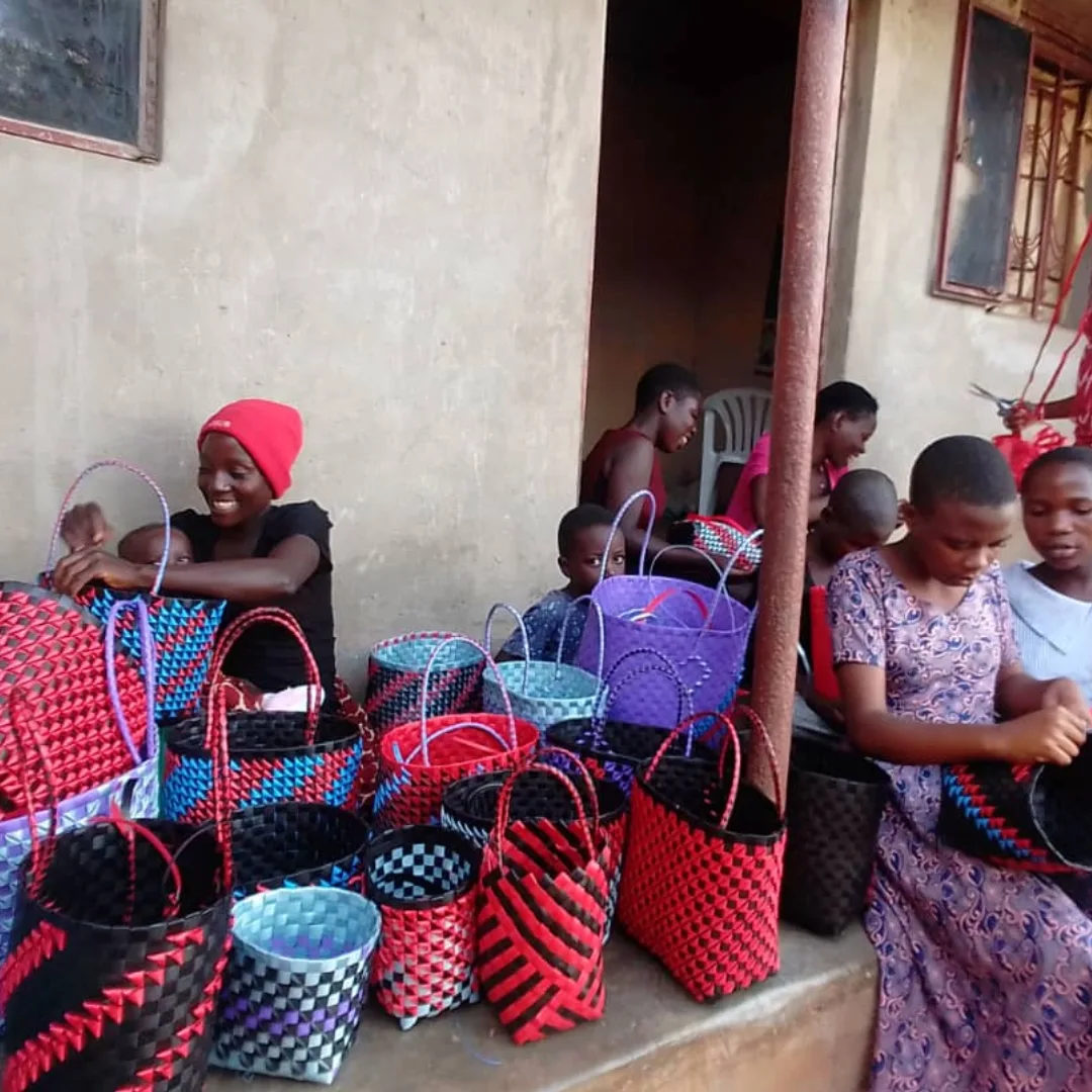 Girls and young mothers weaving colorful handmade bags.