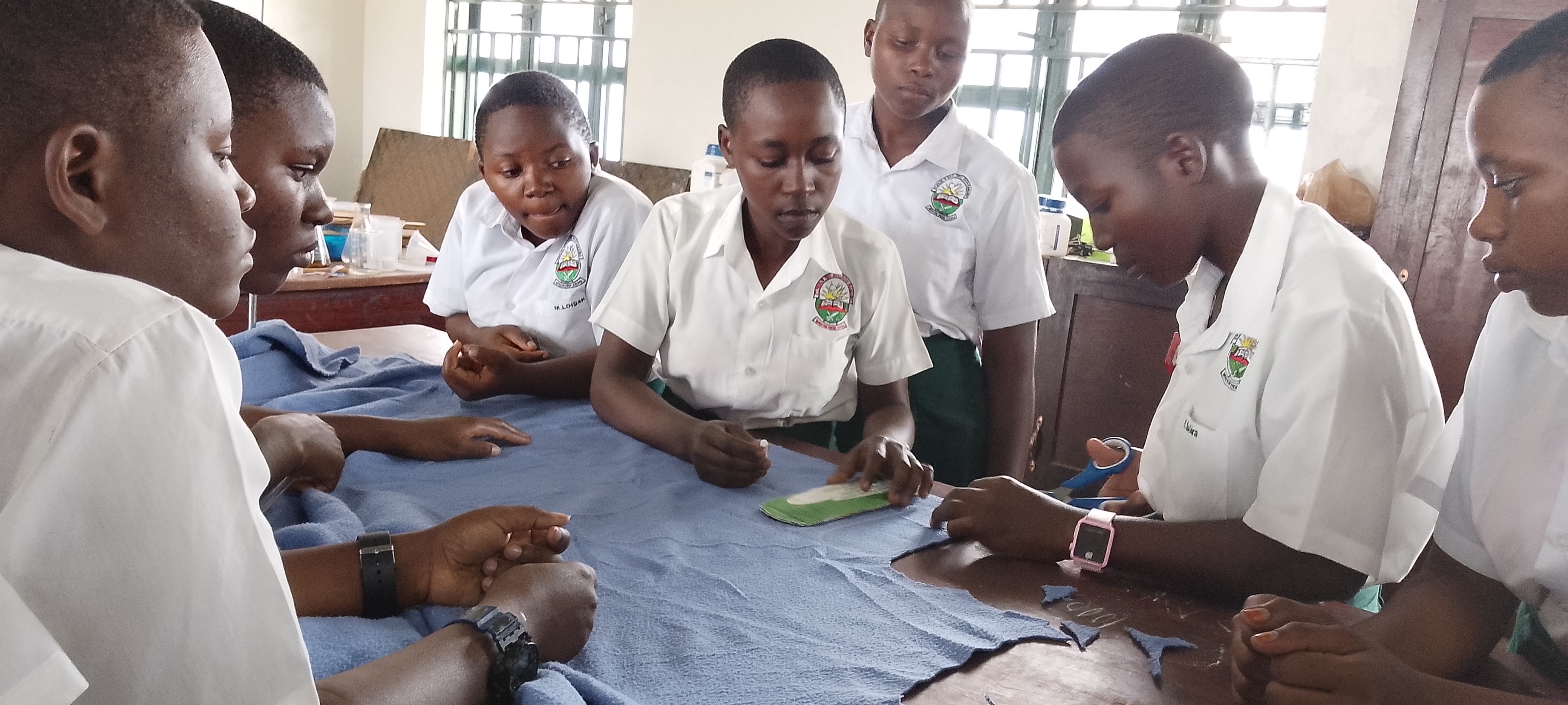 Teenagers learning how to make reusable pads using locally available materials.